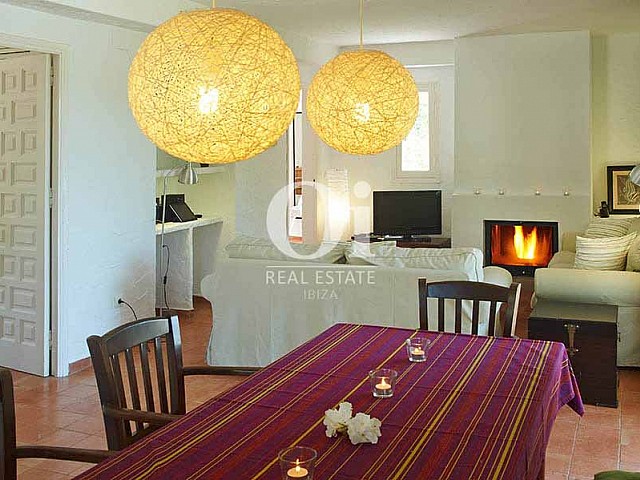 Salón comedor con chimenea de casa en alquiler de estancia en Ses Salinas, Ibiza