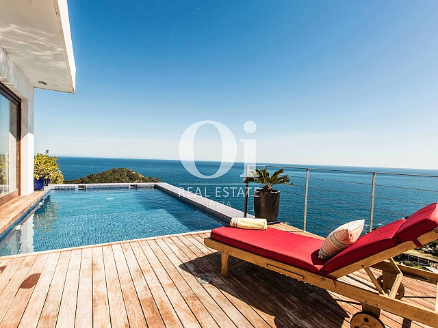 Шикарная терраса с обеденным столом, бассейном и потрясающими видами на море на стильной вилле в краткосрочную аренду на Ибице