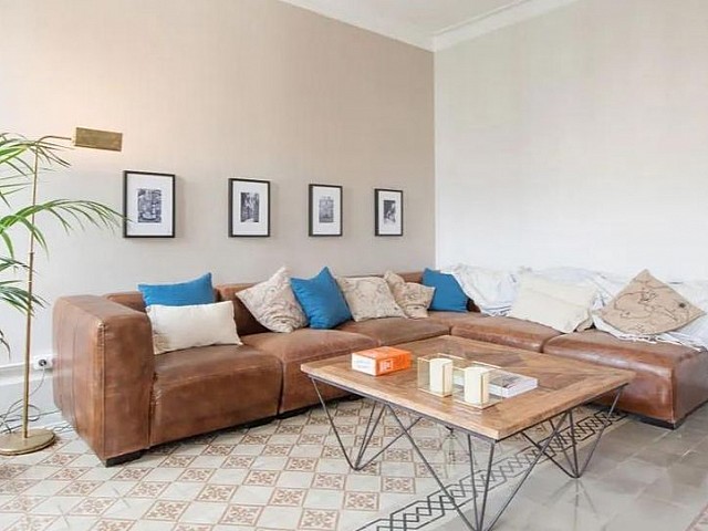 Salón con sofá marrón, cojines azules y mesa de centro de madera