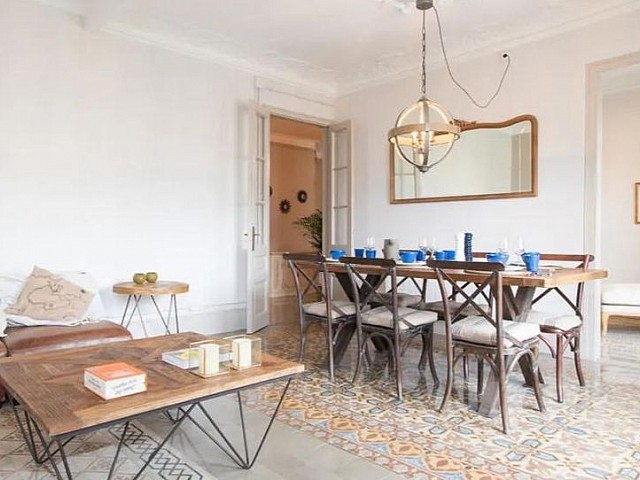 Salón-comedor con mesa larga y vistas al comedor principal al fondo