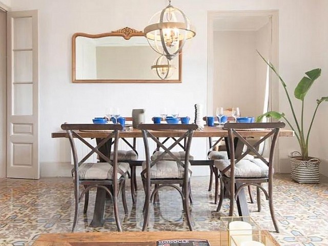 Comedor con espejo decorativo, planta y mesa de madera
