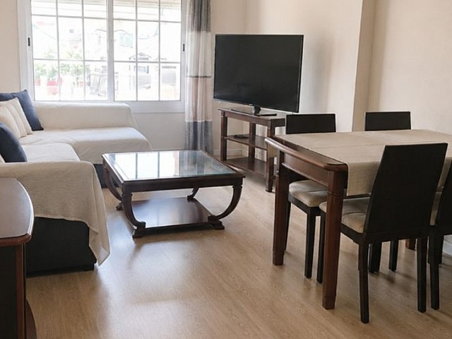 Salón con sofá, mesa de centro y televisión