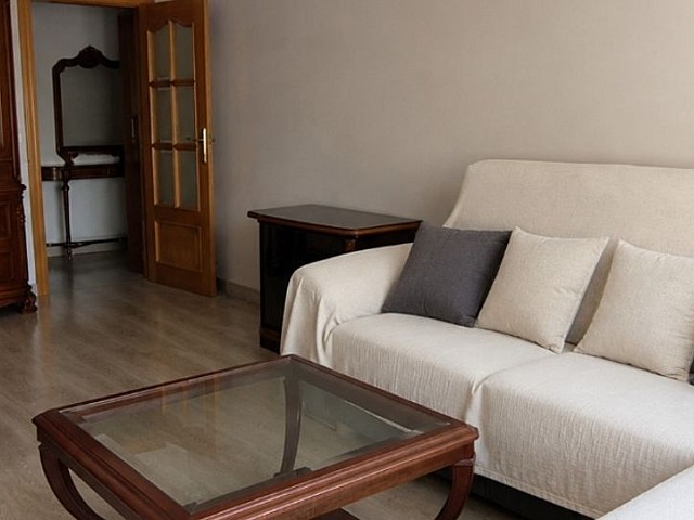 Salón con sofá blanco y mesa de centro con detalles en cristal