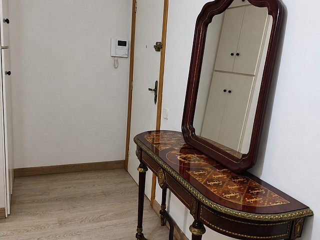 Pasillo con puerta y espejo decorativo