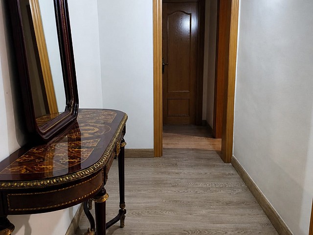 Pasillo con espejo de cuerpo entero y puerta de madera