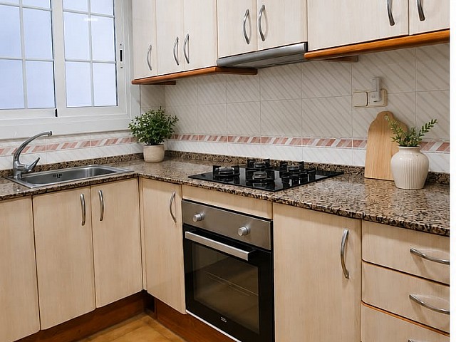 Cocina con muebles blancos y encimera