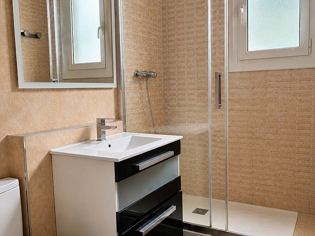 Baño con espejo, lavabo y ventana