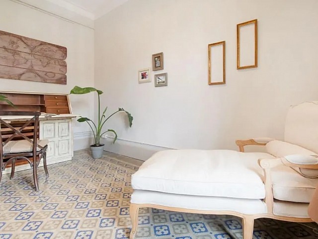 Dormitorio blanco con escritorio vintage, planta y detalles decorativos