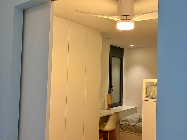 Vista en marco de un dormitorio con ventilador de techo encendido.