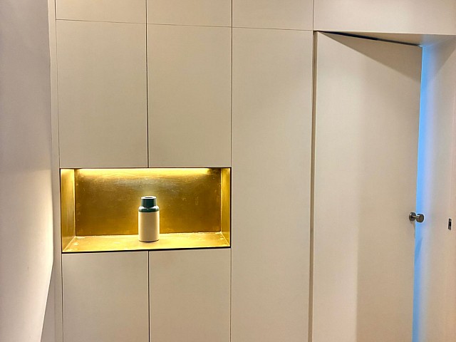 Zona de estudio o despacho con escritorio integrado, ventana y armarios empotrados.