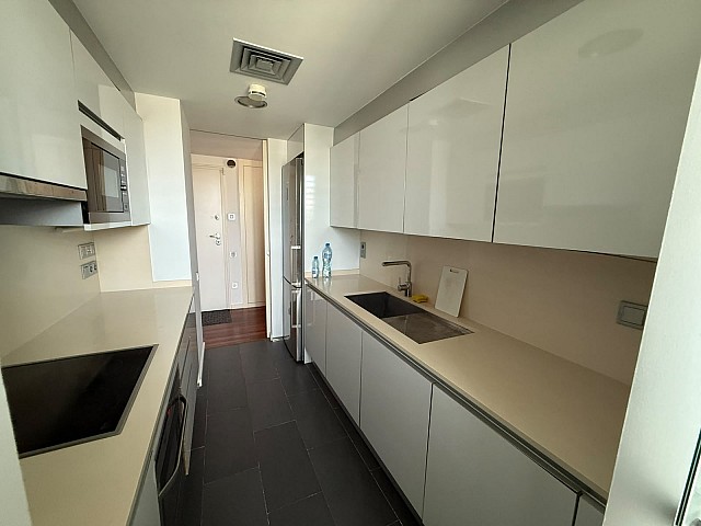 Cocina moderna totalmente equipada con acabados en tonos neutros.