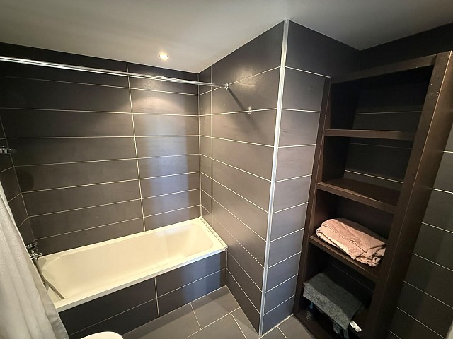 Baño con bañera, amplio espacio de almacenamiento y diseño moderno.