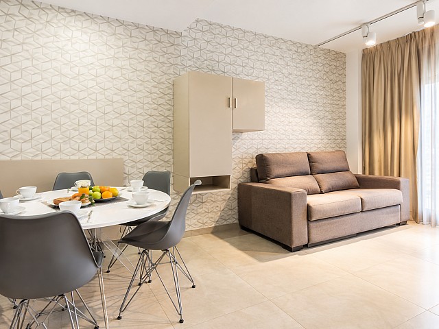 Salón comedor con sofá, mesa y sillas en tonos neutros