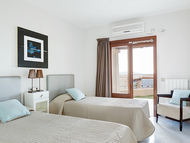 Уютная спальня с большими окнами и потрясающими видами на шикарной вилле в краткосрочную аренду на Ибице