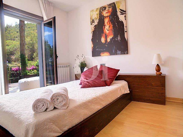Magnifica habitación doble con cama matrimonial y ventanas al exterior en espectacular casa en venta en Ibiza