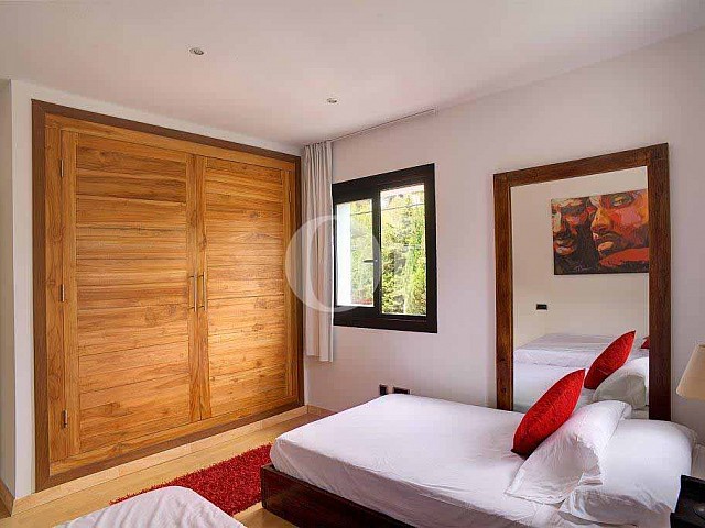 Magnifica habitación doble con cama matrimonial y ventanas al exterior en espectacular casa en venta en Ibiza