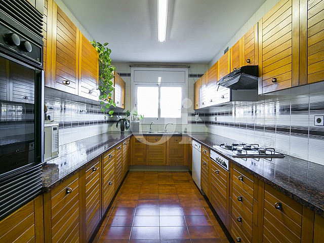Amplia y moderna cocina equipada y de estilo americano en lujoso ático en venta situado en Sant Gervasi, Barcelona