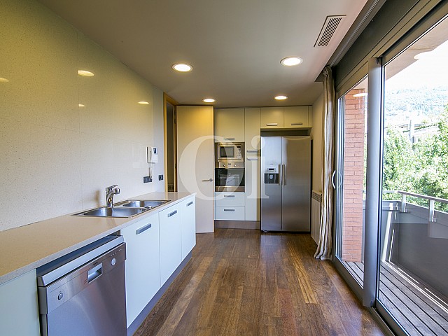 vista de cocina de diseño con salida a balcon en casa de lujo en venta en barcelona