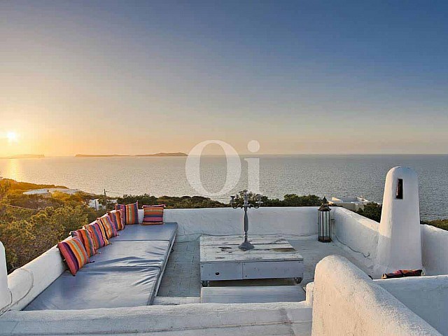 vista de zona de relax con vistas al mar y al atardecer en villa ibicenca en venta 