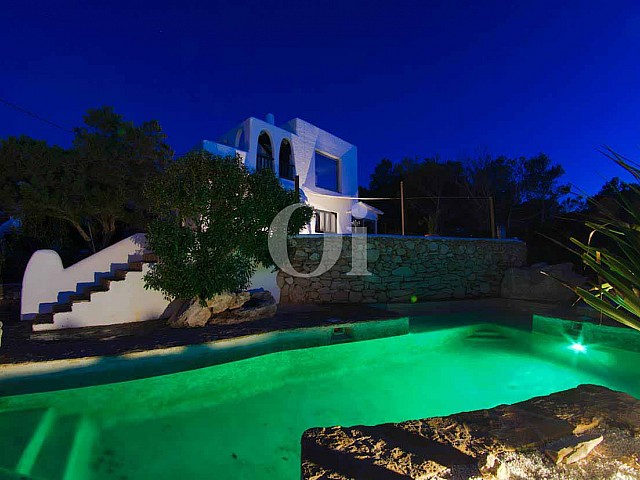vista de piscina iluminada con leds de colores en villa estilo ibicenco en venta 