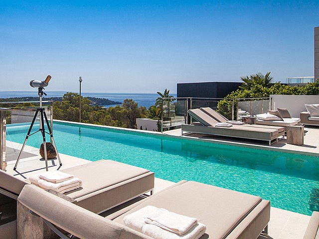 Piscina con hamacas de una impresionante villa de lujo en alquiler en Es Cubells, Ibiza