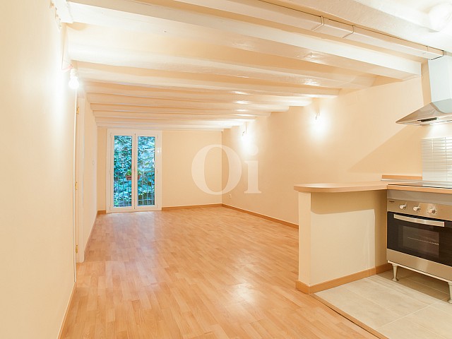 View of living room with built-in kitchen in flat for sale in Raval