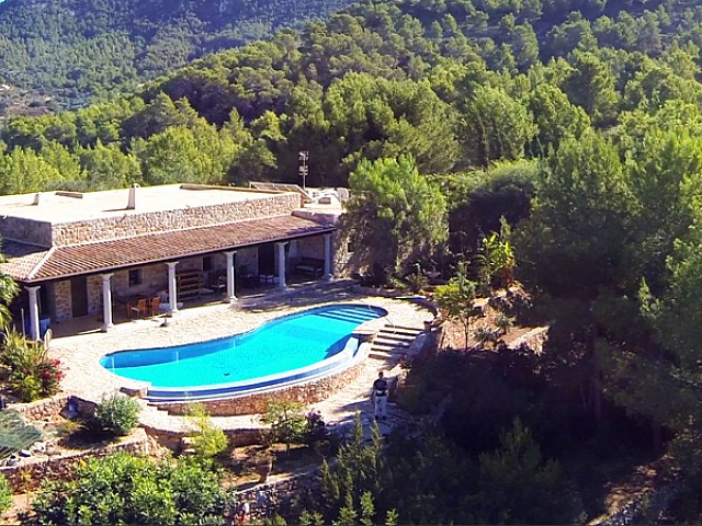 Vistas exteriores de la casa con la gran piscina en la terraza 