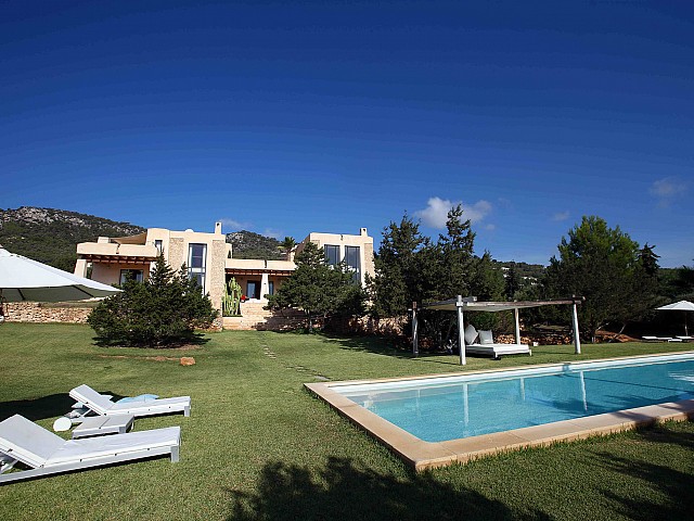 Exteriores de la casa con la piscina en el jardín