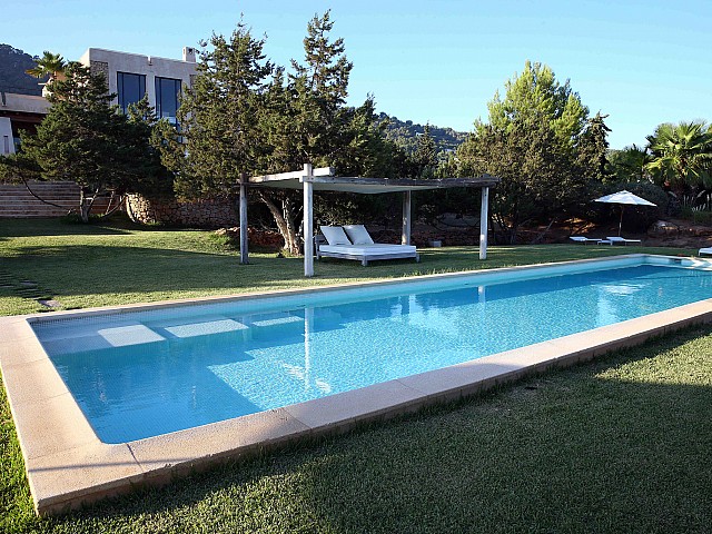 Fantástica piscina con una cama exterior