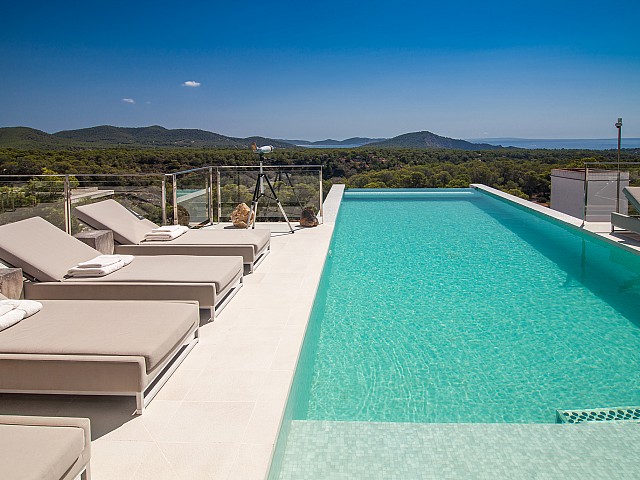 Gran piscina "infinity pool" amb hamaques