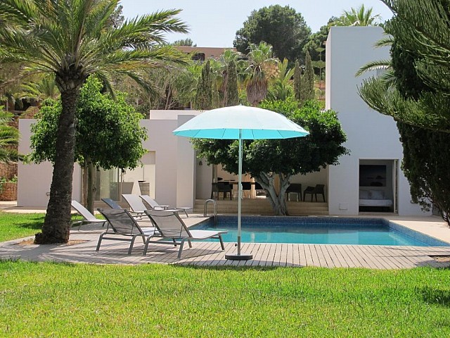 Gran piscina al jardí amb hamaques