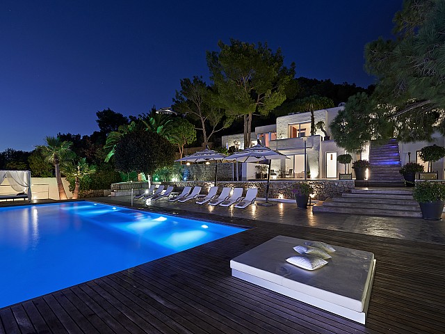 Buena iluminación nocturna de la piscina y la casa