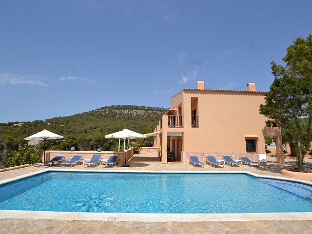 Gran piscina amb hamaques a la part lateral de la casa