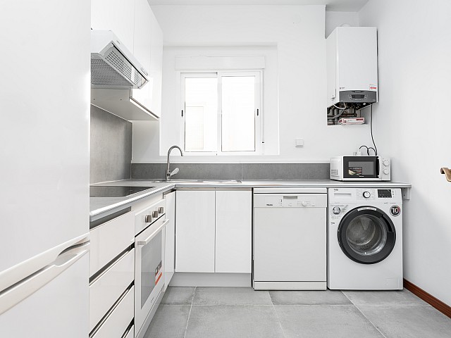 Fitted white kitchen in the penthouse in L’Antiga Esquerra de l’Eixample, Barcelona — view 1